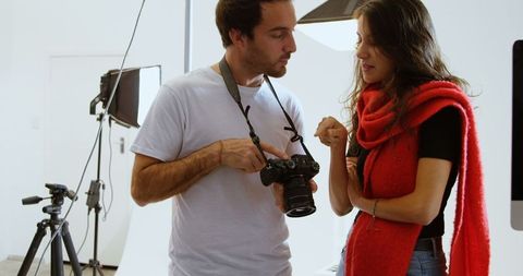 Photographer discussing photos with model in modern studio
