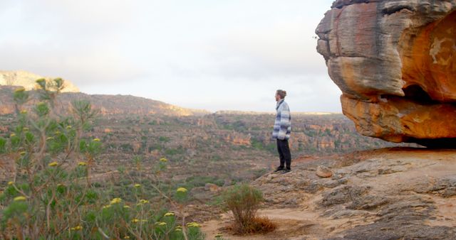 Man Exploring Scenic Desert Landscape Near Rocky Cliff - Download Free Stock Images Pikwizard.com