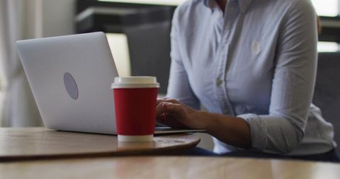 Professional Woman Typing on Laptop in Modern Cafe