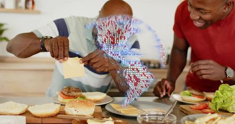 Senior father and son preparing cheeseburgers on counter with holographic globe overlay