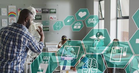 Male Teacher Guiding Kids in Science Class with Digital Medical Icons