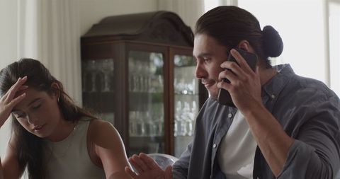 Couple planning wedding celebration with phone and notebook