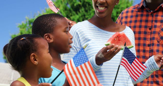 Family Celebrating Independence Day Outdoors with Flags and Watermelon - Download Free Stock Images Pikwizard.com