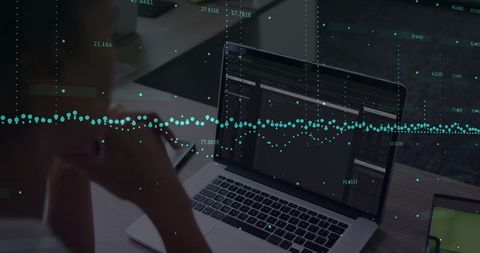 Mid-adult woman analyzing data on laptop with teal visualization overlay at workstation