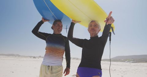 Senior Couple Enjoying Surfing Adventure on Sunny Beach