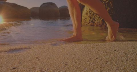 Barefoot Man Walking into Sea During Sunny Beach Day