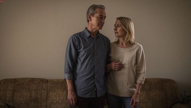 Middle-aged couple standing close looking at each other woman touching partner's chest