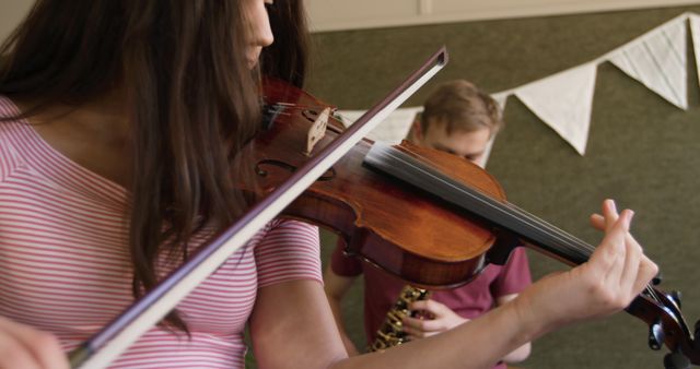 Focused caucasian teenage girl playing violin at school band practice. Music, school, learning, practicing, adolescence, childhood, summer and education, unaltered.