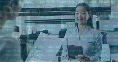 Coworkers Analyzing Stock Market Data on Tablet in Modern Office