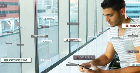 Man using tablet interacting with augmented reality data labels in modern urban office workspace