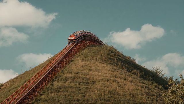 Roller coaster ascending steep hill against clear sky