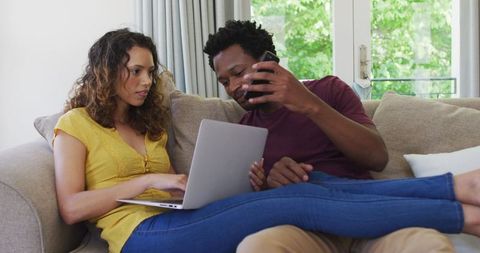 Couple Engaged in Technology on Sofa