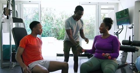 African american friends exercising together in modern gym
