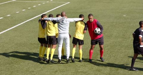Soccer team huddle with coach preparing for match