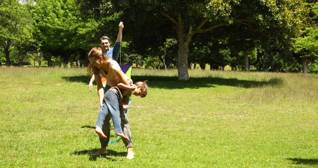 Group of friends enjoying a sunny day in the park, playing and being playful. Perfect for themes related to friendliness, outdoor activities, summertime fun, nature relaxation, and casual engagement. Could be used for advertisements promoting family-friendly activities, recreational areas, or mental health through outdoor fun.