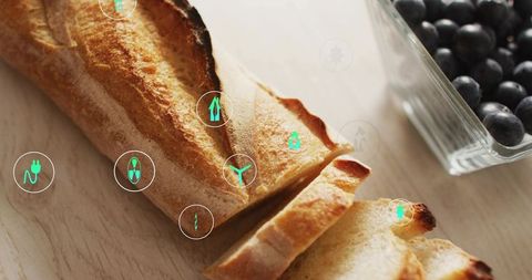Sliced rustic baguette with blueberries and green tech icons suggesting food traceability