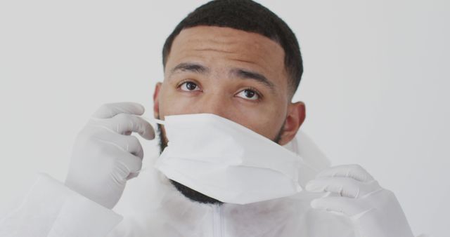 Healthcare Worker Adjusting Face Mask in Protective Gear - Download Free Stock Images Pikwizard.com