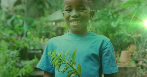 Smiling Boy Holding Plant in Lush Greenhouse Environment