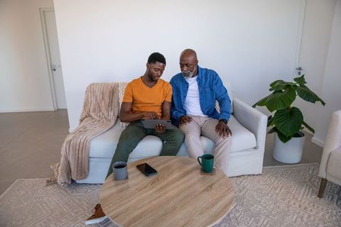 African American Father and Son Bonding with Tablet in Modern Living Room