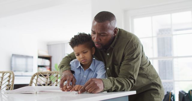 Father Helping Young Boy with Homework in Kitchen - Download Free Stock Images Pikwizard.com