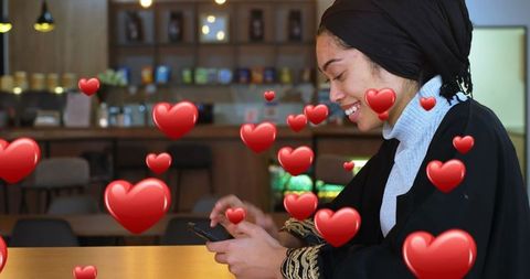 Smiling Woman in Cafe Surrounded by Animated Hearts on Phone