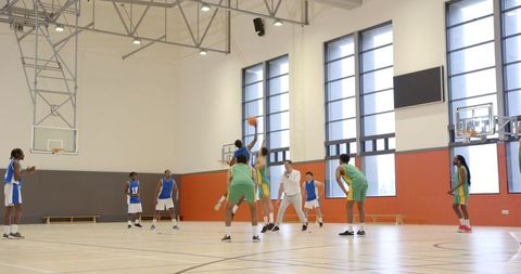 Competitive Basketball Game in Indoor Gymnasium