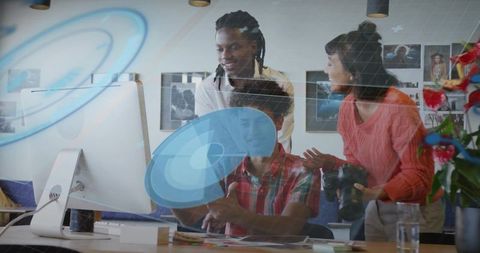 Diverse creative team collaborating at desktop with dslr, digital overlay and color swatches