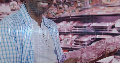 Smiling man holding packaged red meat in supermarket aisle checking freshness and label