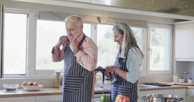 Senior Couple Preparing Meal in Modern Kitchen with Aprons - Download Free Stock Images Pikwizard.com