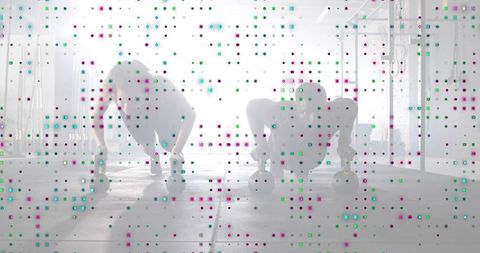 Partners holding plank on kettlebells in backlit gym for strength training and fitness