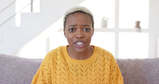 Worried Young Woman Sitting on Sofa Expressing Concern - Download Free Stock Images Pikwizard.com