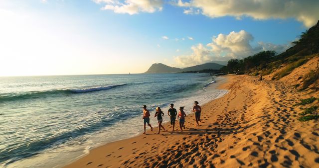 Group of people running along beach at sunset - Download Free Stock Images Pikwizard.com