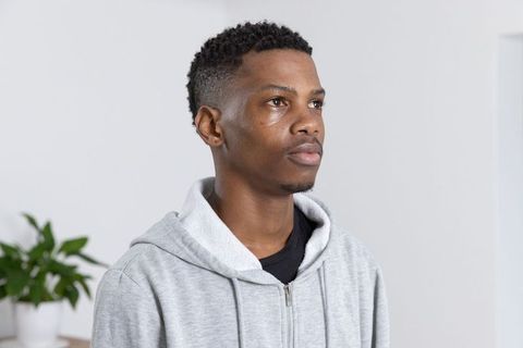 Thoughtful Man in Cozy Hoodie in Minimalistic Interior