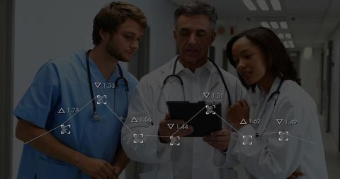 Medical Team Analyzing Digital Tablet in Hospital Corridor