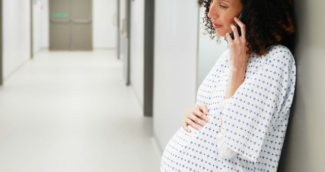 Pregnant Woman in Hospital Gown Talking on Phone in Hallway - Download Free Stock Images Pikwizard.com