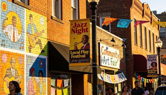 Brick storefront celebrating community art fair with vibrant mural and jazz night banners