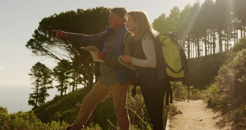 Senior Couple Hiking on Trail Using Map