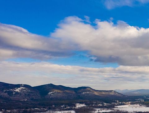 Snow-Dusted Mountain Range Showing Blue Sky and Layered Clouds
