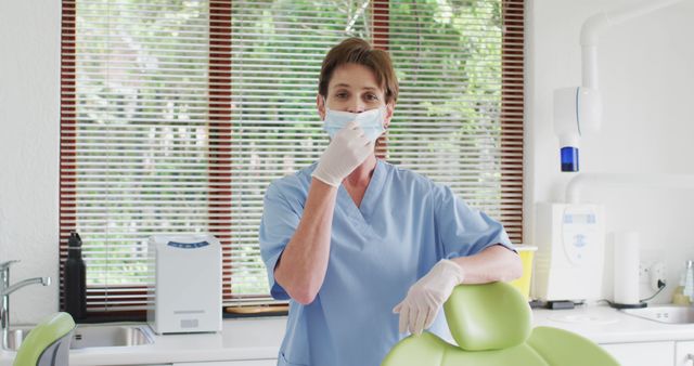 Female Dentist Wearing Mask and Gloves in Clinic Adjusting Face Mask - Download Free Stock Images Pikwizard.com