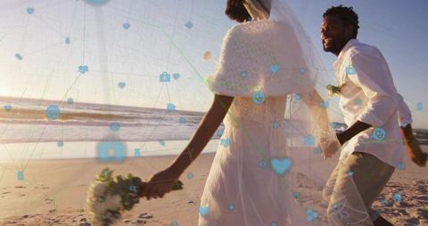 Sunset beach wedding couple walking hand in hand with digital love icons overlay, golden hour