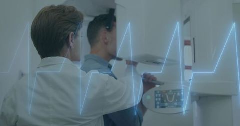 Technologist positioning patient for dental panoramic 3d imaging with digital waveform overlay