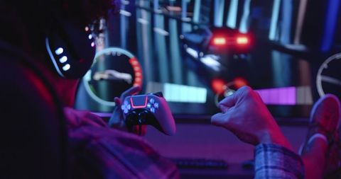 Excited man playing video game joyfully with controller and headphones