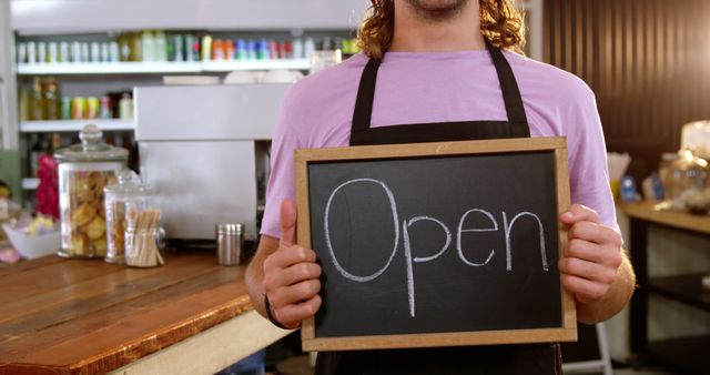 Waiter holding chalkboard with open sign in cafe 4k