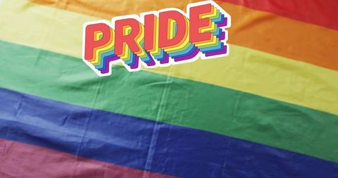 Rainbow pride flag close-up with bold pride sticker, vibrant fabric texture and wrinkles