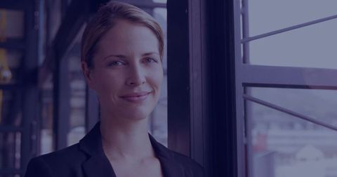 Confident Businesswoman in Modern Office with Cityscape View