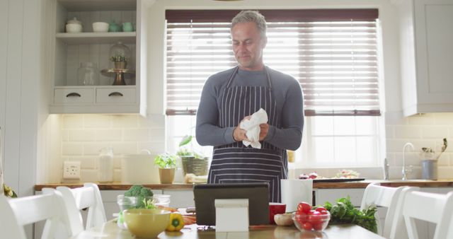 Smiling Man in Kitchen Watching Tablet While Preparing Meal - Download Free Stock Images Pikwizard.com