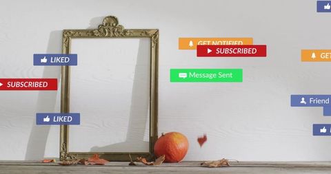 Gilded frame leaning on white wall with pumpkin, autumn leaves, floating badges