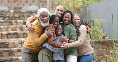 Multigenerational Family Embracing on Garden Steps Showing Warmth and Togetherness