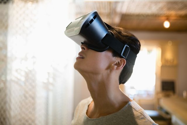 Man enjoying a virtual reality experience in a modern restaurant. Ideal for use in articles or advertisements related to technology, virtual reality, modern dining experiences, and innovative entertainment solutions.