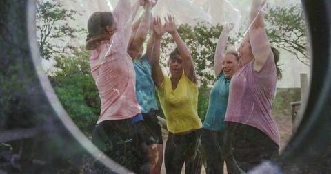 Team of women celebrating victory in an outdoor challenge